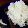 ข้าวสวยในจานและช้อยซ้อมวางอยู่บนโต๊ะไม้