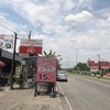 ร้านอยู่หลังป้ายรถเมล์ ป้ายสีแดงเห็นชัดแต่ไกล