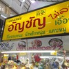 ป้ายเหนือแผงร้าน ตั้งอยู่ข้างบันไดเลื่อนในตลาด