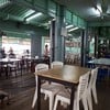 บ้านริมน้ำเก่าทาสีเขียวดูให้บรรยากาศย้อนยุค