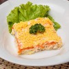 Layered salad with tuna, cheese, carrots, potatos, onion, egg covered with mayon