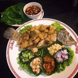 ปลากระพงทอดหั่นเป็นชิ้นพอดีคำ ทานกับผักเคียงและน้ำจิ้มเมี่ยง อร่อยแบบมือไม่เลอะเ