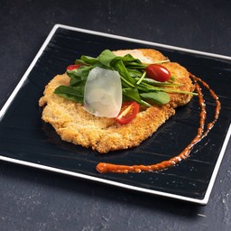 Breast of baby chicken Milanese style with rocket and cherry tomato