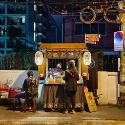 ร้านรถเข็นคล้ายในการ์ตูน มีเก้าอี้เตี้ย 3-4 ตัวคอยบริการลูกค้า