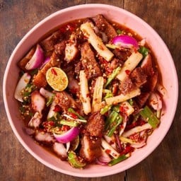 Spicy salad with deep fried pork belly, lotus stem and roasted rice powder