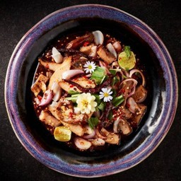 Spicy salad with grilled pork neck, grilled pork udder, grilled pork intestine, roasted rice powder and edible flowers 