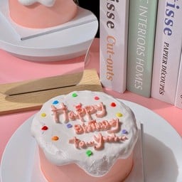 เค้กสีชมพู ลาวาสีขาว แต่งเม็ดสีด้านบน