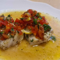 Baked wild fish in garlic lemon and tomatoes relish