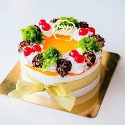 เค้กนมสดหน้าแยมส้มแต่งช็อคโกแลตฝอยทองผูกโบว์