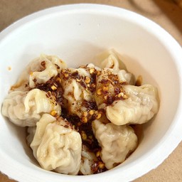 Homemade pork dumplings with spicy chili oil.