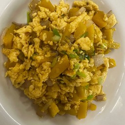 ฟักทองผัดไข่ ราดข้าว Stir-fried pumpkin with egg, served over rice.