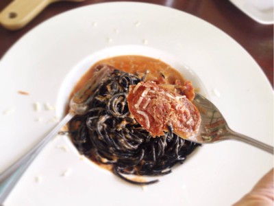 สปาเก็ตตี้เส้นดำผัดซ้อสมะเขือเทศ เบคอน และไส้กรอก