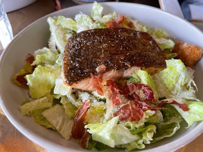 Ceasar salad top with rainbow trout