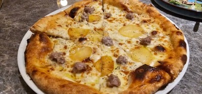 Pizza topped with Taleggio fondue, homemade sausage, roasted potato, & mozzarella cheese