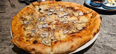 Pizza topped with fresh truffle and mascarpone cheese