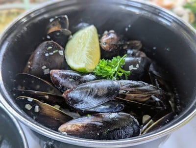 หอยแมลงภู่สีฟ้าอบไวน์ขาวเสิร์ฟพร้อมน้ำจิ้มซีฟู้ดรสจัดจ้าน