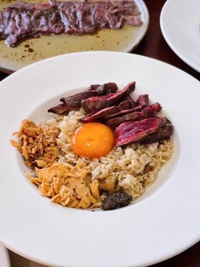 Beef fat fried rice with marinated egg yolk + sliced beef served with truffle sauce