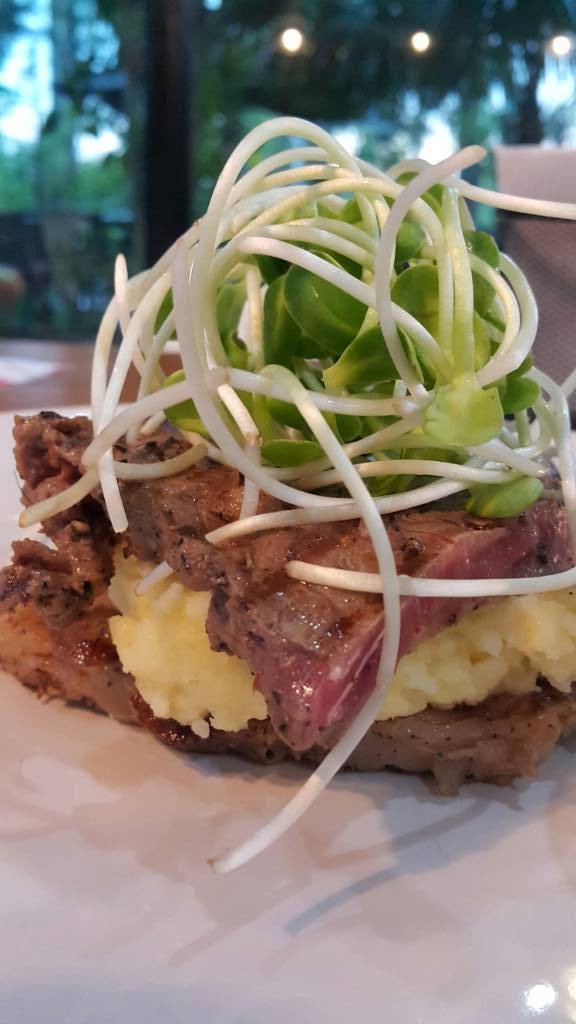 สเต็กเนื้อเสริฟกับมันบดประคบหน้าด้วยต้นอ่อนทานตะวัน