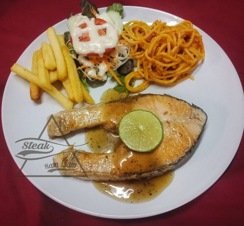 สเต็กแซลมอลชิ้นใหญ่เสริฟพร้อมเครื่องเขียง เฟรนฟรายสลัดและสปาเก็ตี้ผัดซอส จัดว่าเ