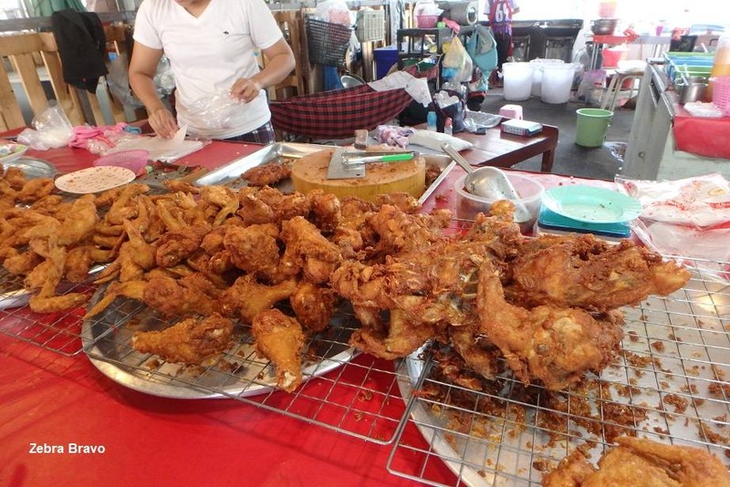 ไก่ทอดร้อนๆ เพิ่งขึ้นจากกระทะด้านหลัง