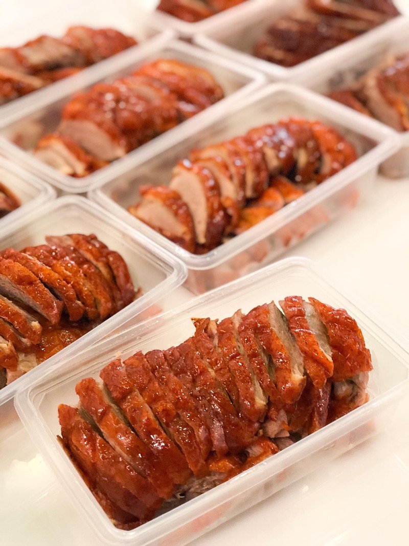 เป็ดย่างแบบครึ่งตัว ทางร้านสับเป็นชิ้น สำหรับครึ่งตัวใส่กล่องให้ พร้อมน้ำราด ผัก